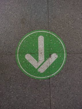 Gri seramik zeminde yeşil ok işareti