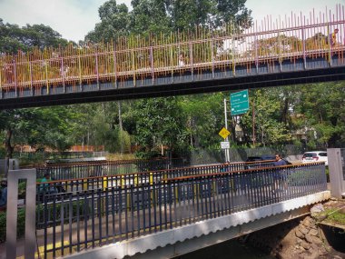 two pedestrian bridges with colorful square iron railings facing each other clipart