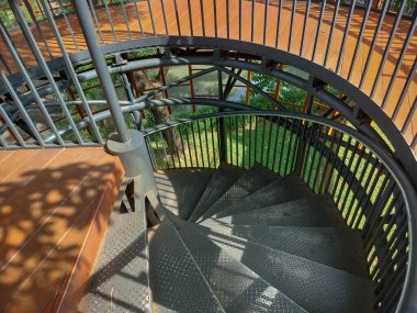 Siyah basamaklı demir sarmal merdiven ve siyah demir boru rayı.