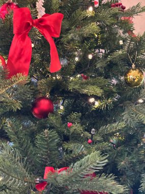 Kırmızı fiyonklu ve altın toplu Noel ağacı.