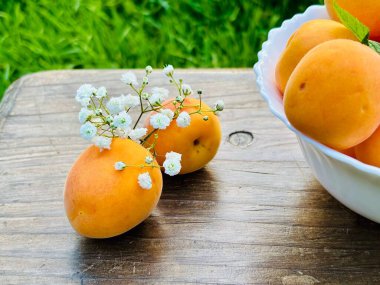 Tahta bir masada taze şeftali ve kayısılar.