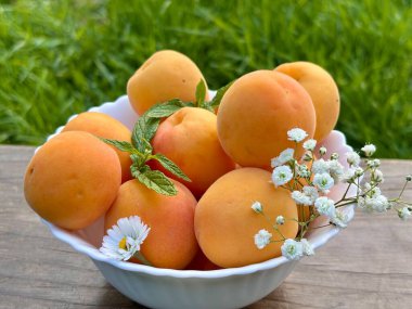 Tahta masadaki kasede taze kayısılar.