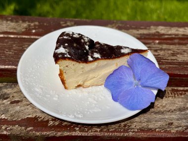 Bir dilim pasta ve bir çiçeğin dikey çekimi.