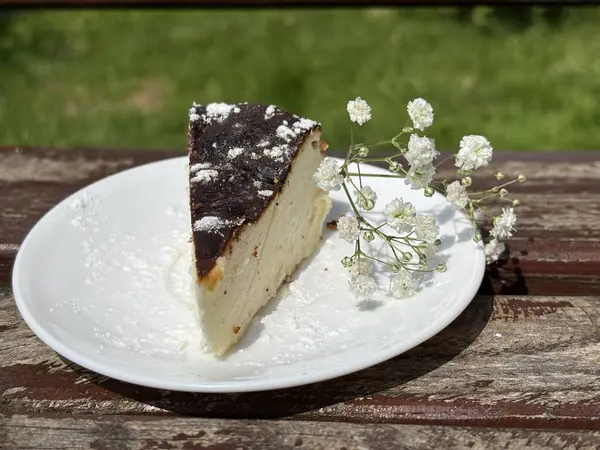 Kafedeki masada beyaz tabakta bir parça kek.