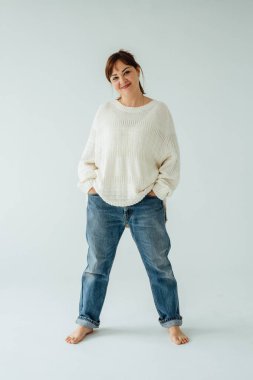 Kendine güveni tam bir yetişkin kadının stüdyo portresi. Günlük kıyafetler içinde, güçlü ve rahat bir tavır takınıyor.