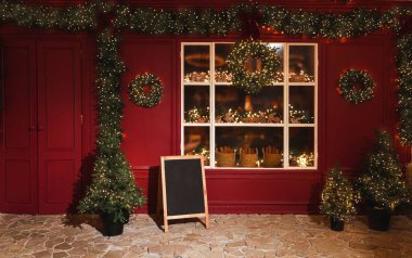 Sokakta yılbaşı süslemeleri. Çelenkli Noel ağaçları, vitrinler
