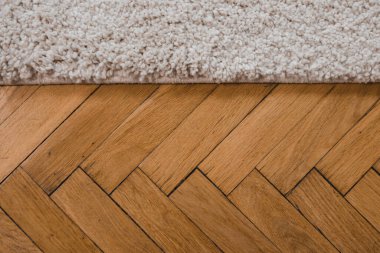 İyi korunmuş eski parke döşeme ve modern halı. Ahşap doku ve halı yığını