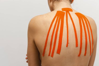 Sırtında bantlarla beyaz arka planda bir bayan sporcu. 