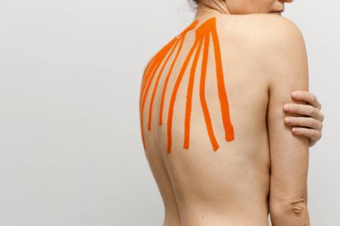 Sırtında bantlarla beyaz arka planda bir bayan sporcu. 