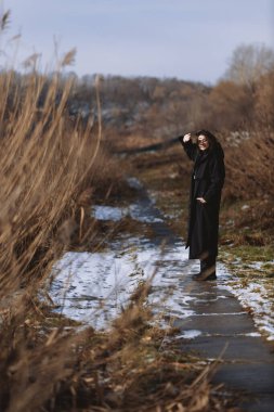A beautiful girl walks on a sunny winter day 