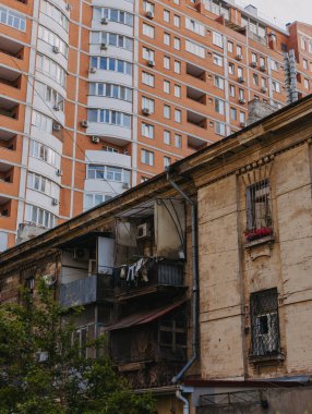 Eski bir ev, modern bir gökdelenin arka planına karşı.