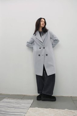 Güzel moda kızı şık bir ceketle poz veriyor.