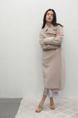 Güzel moda kızı şık bir ceketle poz veriyor.