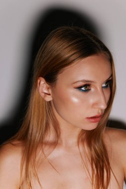 Hafif bir arka planda makyaj ve duyguları olan güzel bir kızın minimalist güzel portresi.