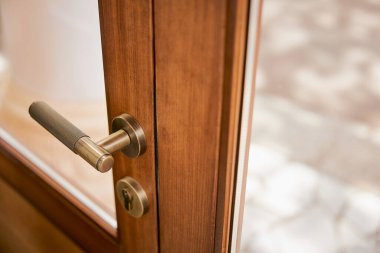 Güzel, modern bir kapı kolu, eski bir tarzda restore edilmiş bir kapıda. 