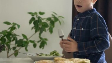 Şirin küçük çocuk kahvaltı yiyor. Sağlıklı yemek yiyor. Yemek yiyor, yemek yiyor. 2x Yavaş çekim 60 fps 4K