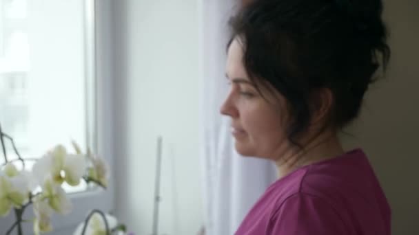 Tender Woman Prend Soin Des Fleurs Orchidée Regardant Fenêtre Expression — Video