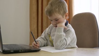 Little Boy Mesafe Uzaktan Çalışma İnternette Müzik Masasında Oturuyor. Yavaş çekim 4K