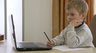 Little Boy Mesafe Uzaktan Çalışma İnternette Müzik Masasında Oturuyor. Yavaş çekim 4K