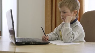 Little Boy Mesafe Uzaktan Çalışma İnternette Müzik Masasında Oturuyor. Yavaş çekim 4K