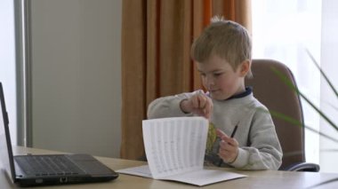 Little Boy Mesafe Uzaktan Çalışma İnternette Müzik Masasında Oturuyor. Yavaş çekim 4K