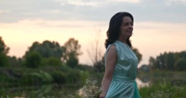 Çiçekli Kadın Dans Ediyor Dönen Keyfini Doğanın Yakınındaki Nehir 'de Dinlen. Yaz sezonu günbatımı. Kırsal Ülke Sahnesi 4K