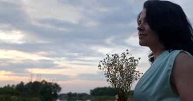 Çiçekli Kadın Sunset 'e bak, Doğanın Yakınındaki Nehir' de Dinleniyor. Yaz sezonu. Kırsal Ülke Sahnesi 4K