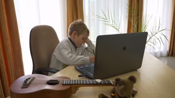 Маленький Хлопчик Дистанційне Навчання Онлайн Музики Вдома Сидить Столі Повільний — стокове відео