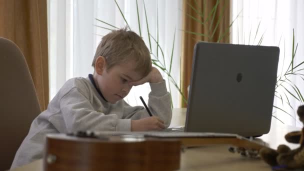 Little Boy Afstandsbediening Studeer Online Muziek Thuis Zitten Aan Balie — Stockvideo