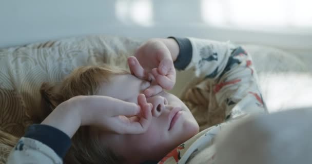 睡梦中男孩睁开眼睛 睡梦中的孩子在卧室的床上醒来 家舒适 10位 — 图库视频影像