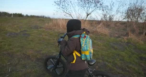田舎ダートロードのキッズボーイライドバイク 子供は田舎で自然を楽しんでいる ウィンター イブニング 10ビット — ストック動画