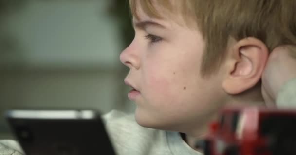 Upset Boy スマートフォンをプレイする 悲しい子供の顔の表現フラストレーション感情 スマートフォンを使用した子供 スローモーション ビット — ストック動画
