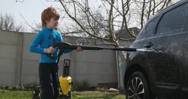 Παιδί Χρησιμοποιεί Πλυντήριο Αυτοκινήτων Πίεσης Για Καθαρίσει Αυτοκίνητο Στην Πίσω Royalty Free Πλάνα Αρχείου