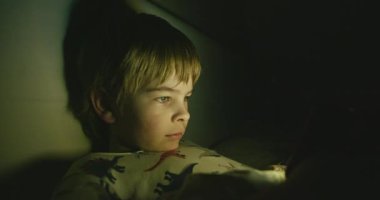 Akıllı Telefon Ekranında Çocuk İzleme Videosu. Geceleri Karanlıkta Yatak Odasında Yatan Çocuk. Çocuk Gözü İfade Duygusu. 4K 10-bit