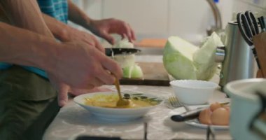 Yakından hazırlayan omlet. Erkekler Mutfak Hazırlama Kahvaltısı 'nda yemek pişiriyor. Yavaş çekim 60fps 4K