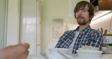 Adam Fıstık ve Ceviz Yiyiyor Mutfakta oturuyor. Yavaş çekim 60 fps 4K 10-bit