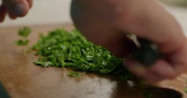 Bıçaklı, pirzola kesimli maydanozlu erkek eli. Salatayı hazırla. Erkekler Mutfak Hazırlama Kahvaltısı 'nda yemek pişiriyor. Yavaş çekim 60fps 4K 10-bit