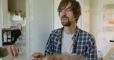 Beyaz Kafkasyalı adam mutfakta sağlıklı vejetaryen yemeği yiyor. Yavaş çekim 60fps 4K 10-bit