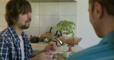 Beyaz Kafkasyalı adam mutfakta sağlıklı vejetaryen yemeği yiyor. Yavaş çekim 60fps 4K 10-bit