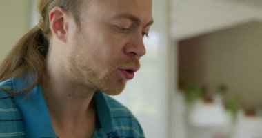 Beyaz Kafkasyalı adam mutfakta sağlıklı vejetaryen yemeği yiyor. Yavaş çekim 60fps 4K 10-bit