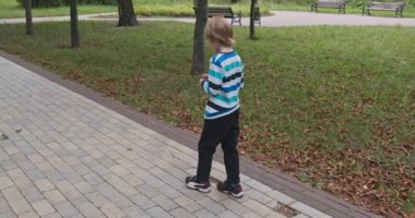 Yalnız Çocuk Şehir Parkı 'nda Tek Başına Yürüyor. Yaz Günü 4K 10-bit