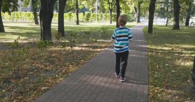 Akıllı Telefonlu Çocuk Şehir Parkı 'nda Tek Başına Yürüyor. Yaz Günü 4K 10-bit