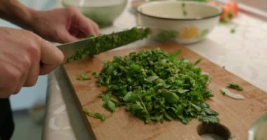 Bıçaklı Erkek El salata için yeşil bitkileri kesti. Mutfakta Bekar Adam Kahvaltı ya da Akşam Yemeği Hazırlıyor. Yavaş çekim 60fps 4K