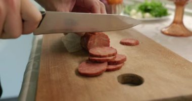 Bıçaklı sosisi dilimlere ayırır. Mutfakta Kafkas Adam Kahvaltı ya da Akşam Yemeği Hazırlıyor. Yavaş çekim 60fps 4K 10-bit