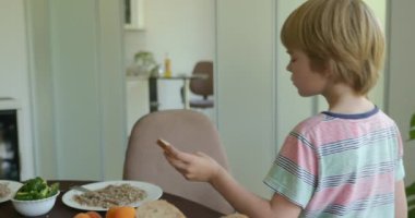 Çocuk çocuk akşam yemeğinde karabuğday lapası ve sandviç yiyor. Yavaş çekim 60fps 4K 10-bit