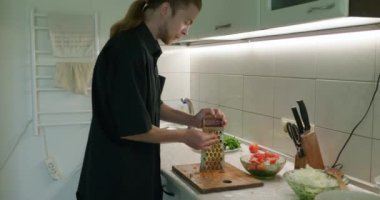 Salata için Erkek El Izgara Havuçları. Mutfakta Bekar Adam Kahvaltı ya da Akşam Yemeği Hazırlıyor. Yavaş çekim 60fps 4K 10-bit