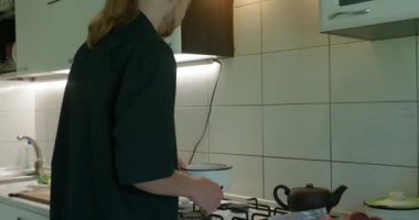 Mutfakta Bekar Adam Kahvaltı ya da Akşam Yemeği Hazırlıyor. Yavaş çekim 60fps 4K 10-bit