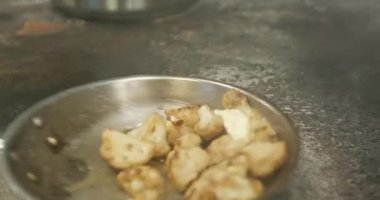 Karnabahar kızartma tavasında. Restoran Mutfağında Şef Cook 'tan yemek hazırlığı. Yavaş çekim 60fps 4K 10-bit