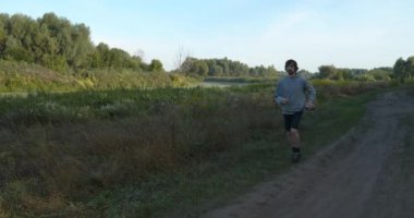 Genç Kafkas Adam Kırsal Doğada Koşuyor. Yavaş çekim 60fps 4K 10-bit