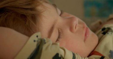 Uyuyan şirin küçük çocuk. Çocuk, Yatak Odasında Sabah Yatağında Uyuyor. 4K 10-bit